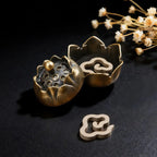 Decorative brass incense holder with floral design on a black background