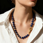 Blue beaded necklace with a gold clasp on a mannequin wearing a white shirt.