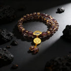 Liuli glass beaded bracelet with a gold charm on a dark surface