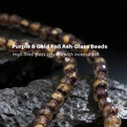 Purple and gold foil ash-glass beads on a dark background