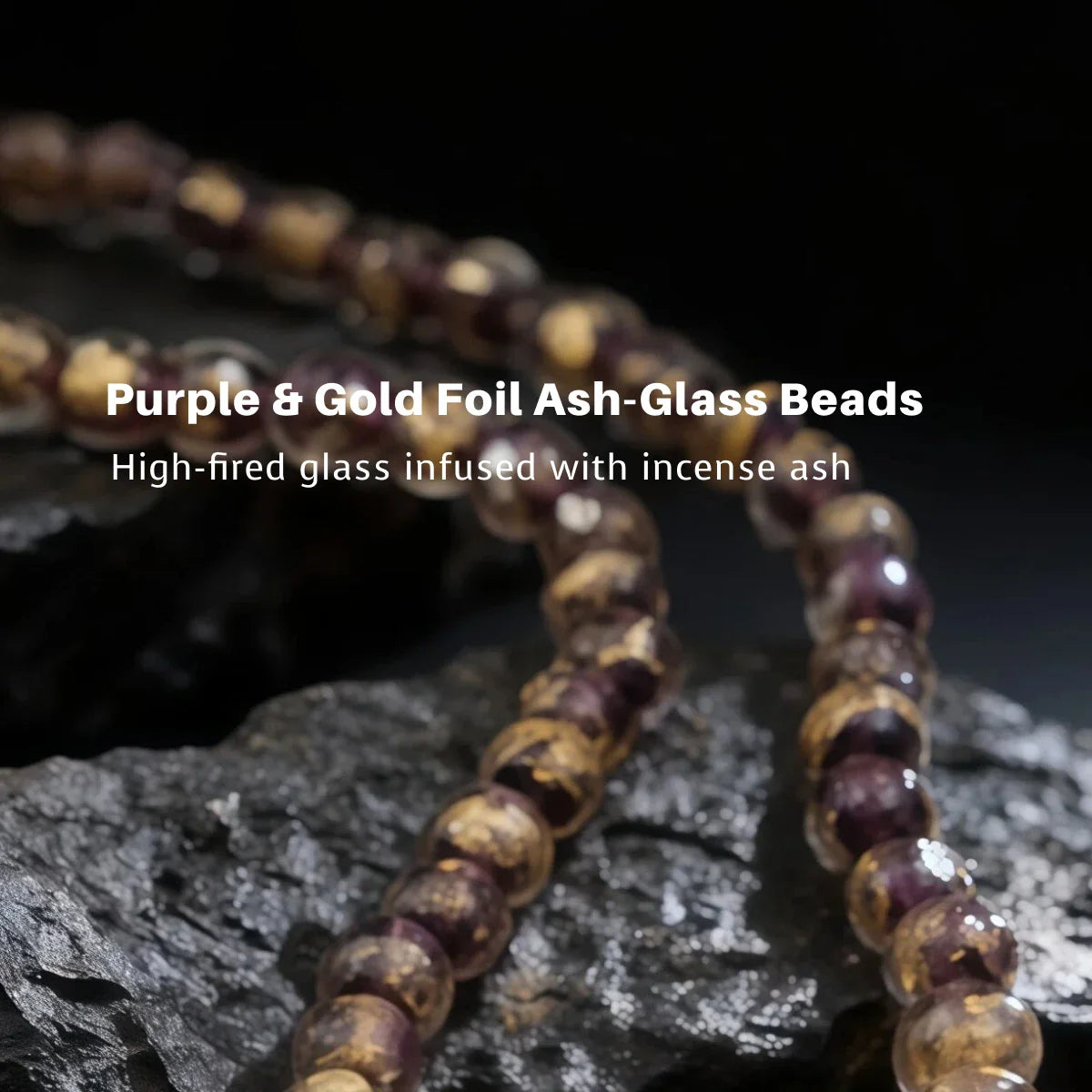 Purple and gold foil ash-glass beads on a dark background