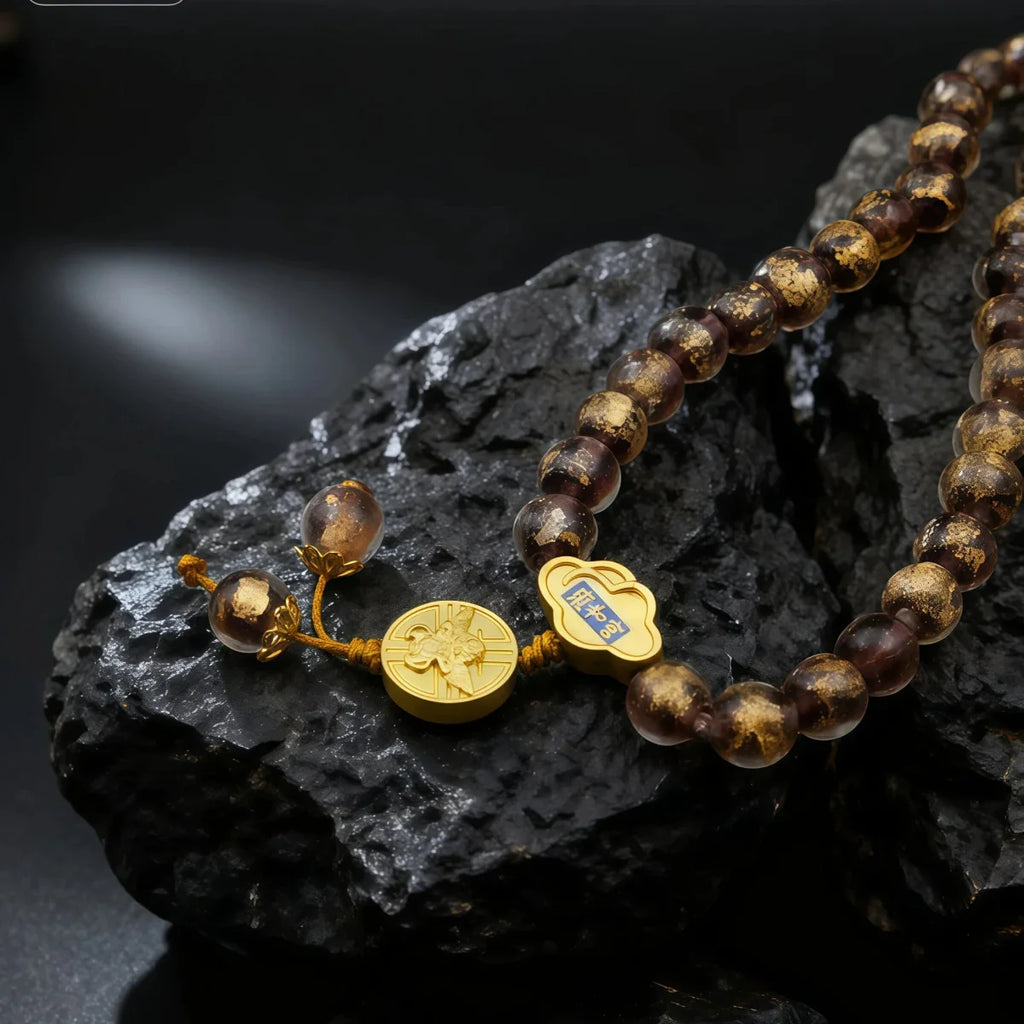 Beaded bracelet with gold accents on a dark rock surface