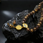 Beaded bracelet with gold accents on a dark rock surface