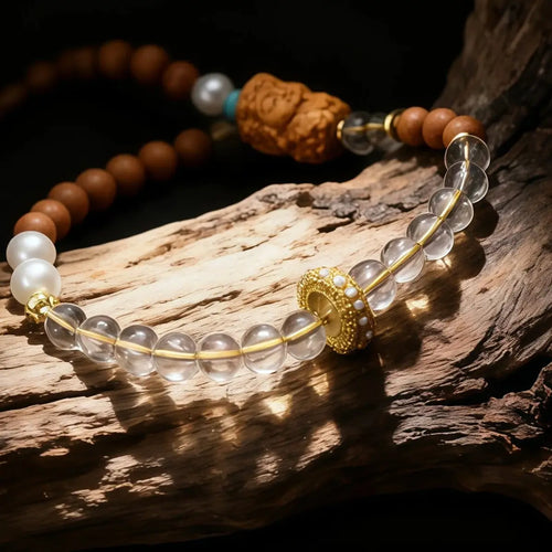 Sandalwood Buddha Charm Phone Strap with gold accents on a wooden surface