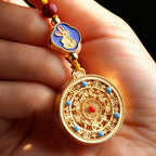 Gold pendant with intricate design held in a hand