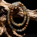 Stack of beaded bracelets with gold accents on a wooden surface