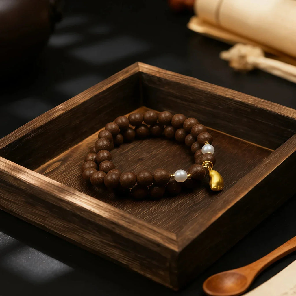 Tibetan incense beaded bracelet with a gold accent on a wooden tray