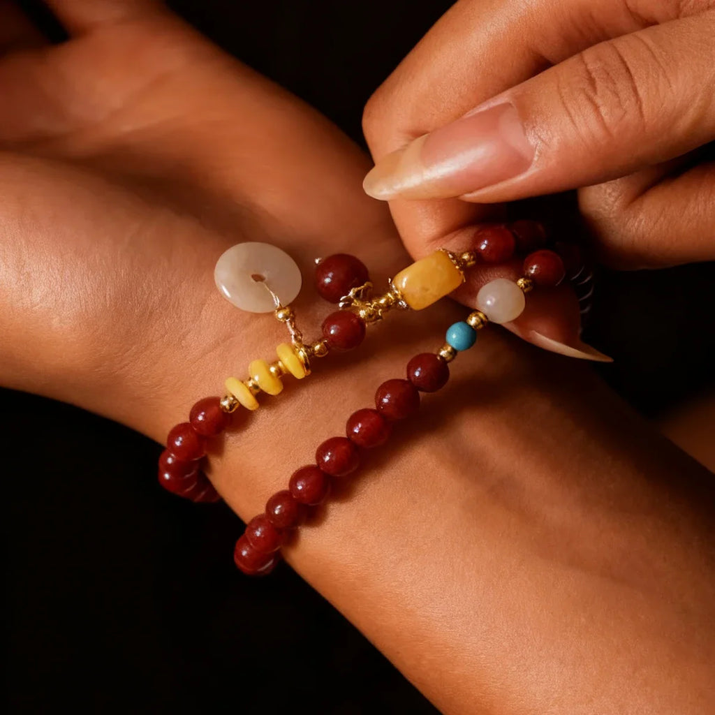 Close-up of a wrist wearing a bracelet with clear beads against a neutral background