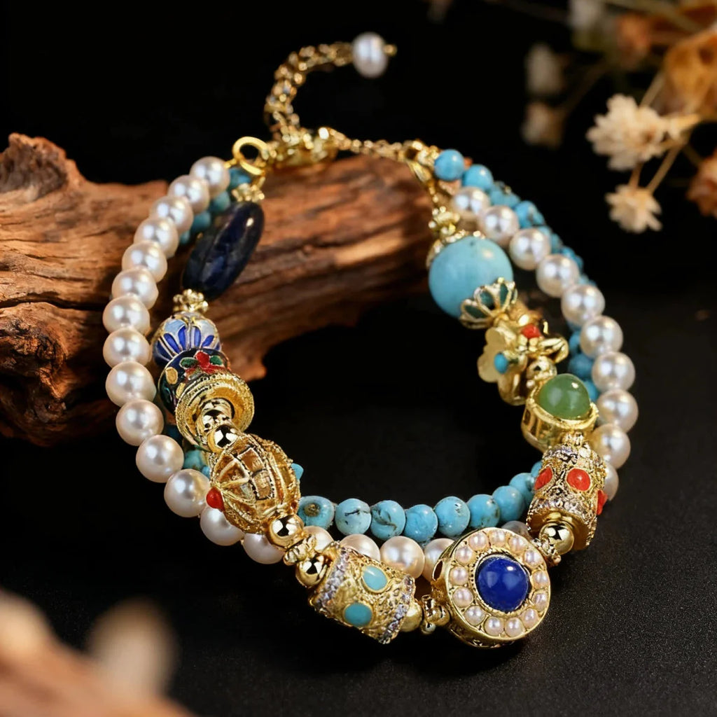 Decorative tibetan triple bracelet with pearls, turquoise stones, and gold accents on a dark background.