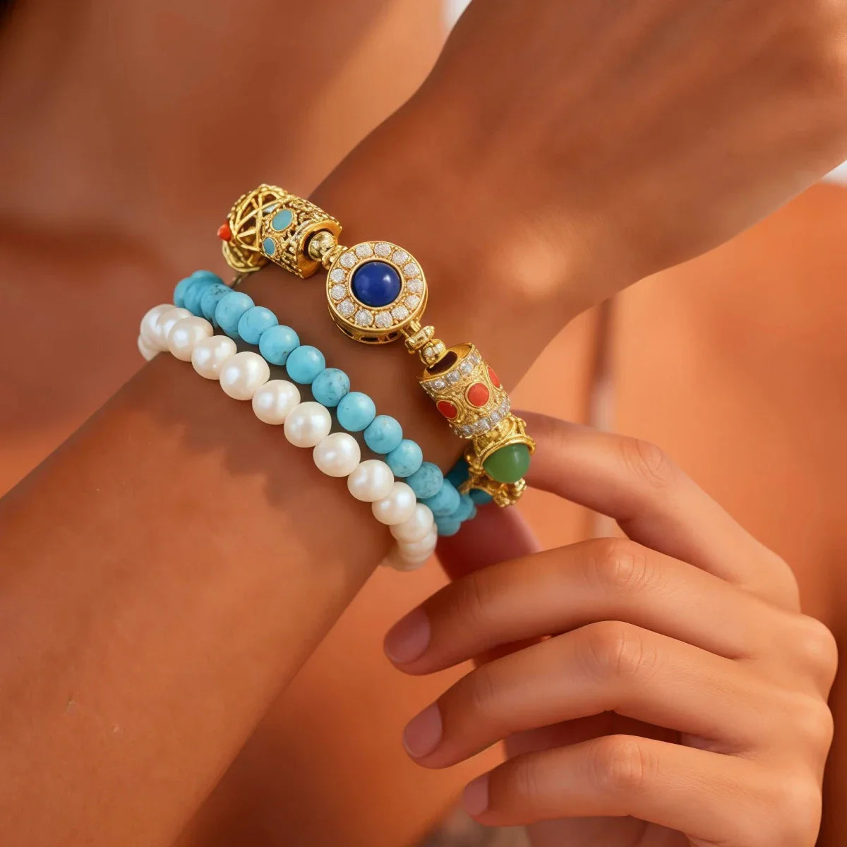 Close-up of a hand wearing Triple Celestial Flow Bracelet with intricate designs on a blurred background