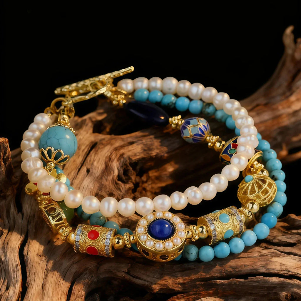 Multistrand bracelet with pearls, turquoise beads, and gold accents on a wooden surface