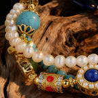 Pearl and gemstone bracelet with gold accents on a wooden surface