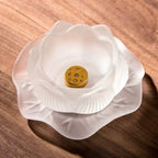White flower-shaped incense holder with a gold center on a wooden surface