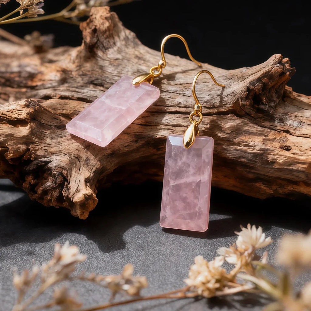 Rose Quartz earrings on gold hooks with a natural wood and floral background