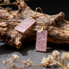 Rose Quartz earrings on gold hooks with a natural wood and floral background