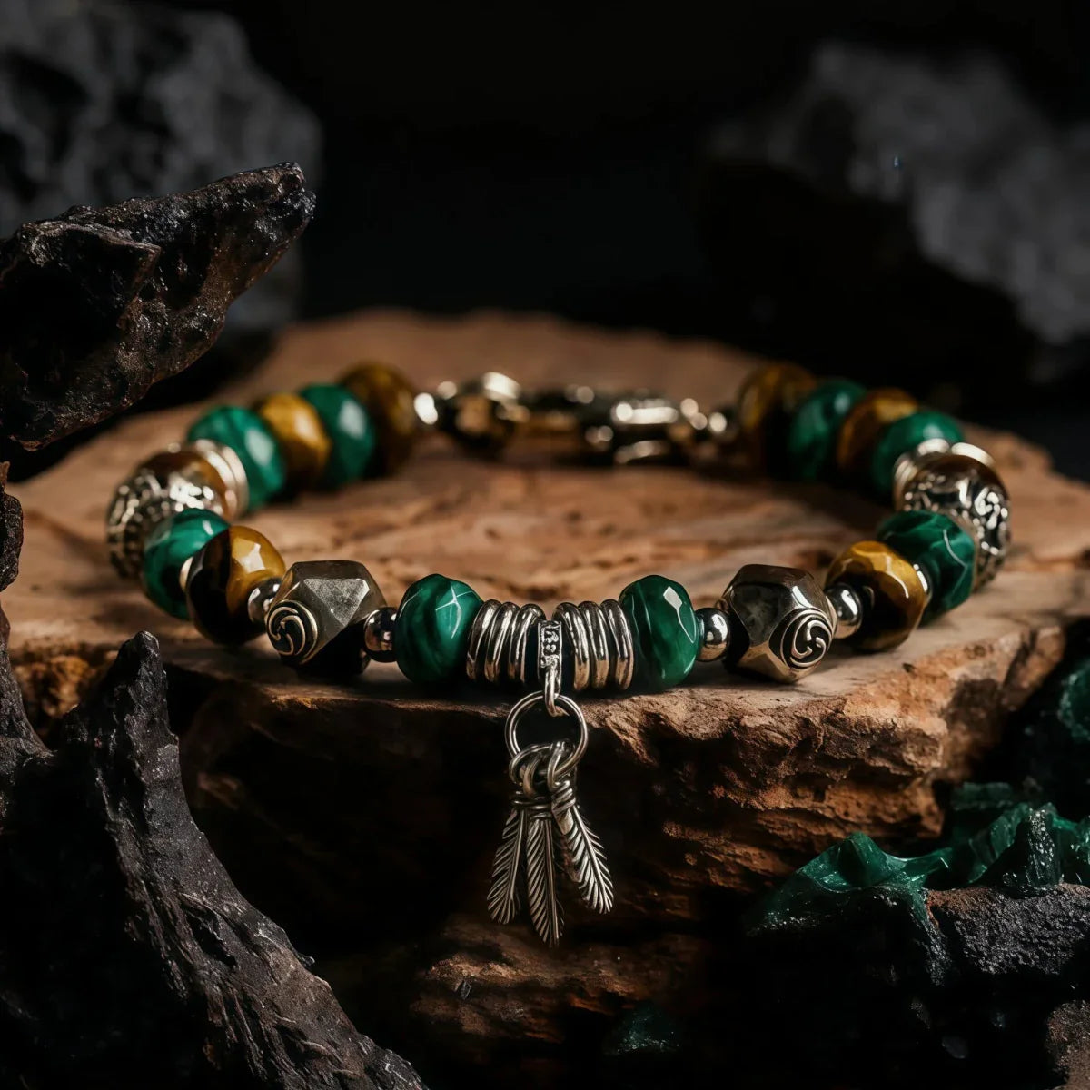 Tibetan Bracelet with green and gold beads and a feather charm on a wooden surface.
