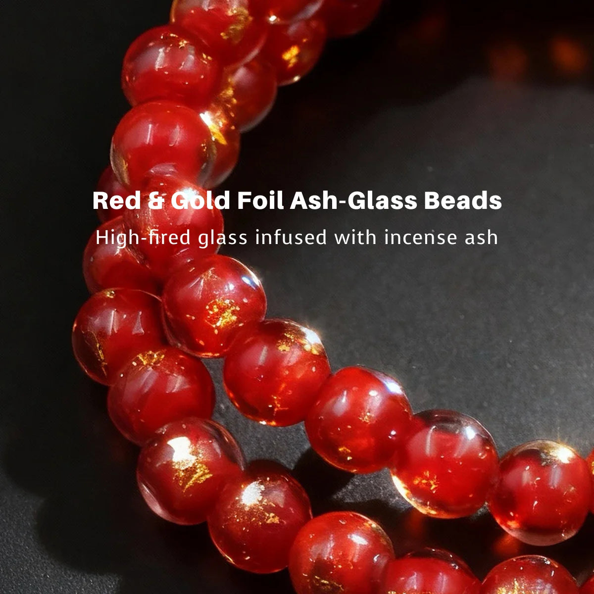 Red and gold foil ash-glass beads on a dark background