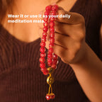 Red beaded mala held by a person with text overlay on a blurred background