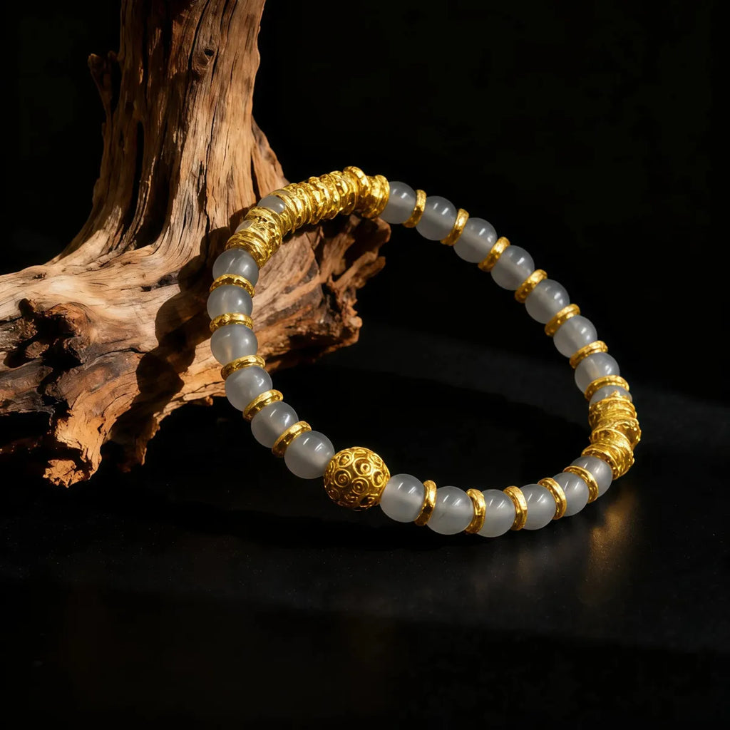Gray agate fortune bracelet with gold-accented beads, natural stone jewelry on a dark background