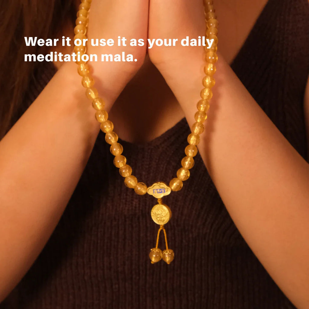 Gold beaded necklace held by hands with text overlay on a dark background